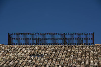 Brick wall and building against blue sky