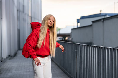 Cheerful african american woman with long blonde hair wearing sportswear and wearing headphones