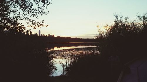 Scenic view of river against sky at sunset