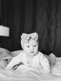 Portrait of cute baby girl on bed at home