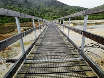 View of footbridge leading towards mountains