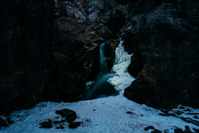 Scenic view of frozen waterfall against rocks