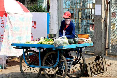 Side view of man having food on street in city