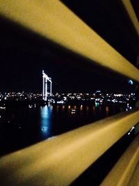 Illuminated bridge over river at night