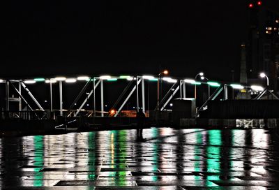 Illuminated bridge over river at night