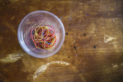 Directly above shot of rubber bands in bowl on table