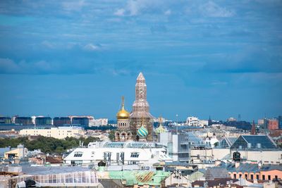 Buildings in city against cloudy sky