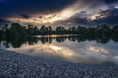 Scenic view of lake against sky at sunset