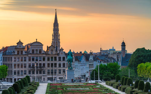 Buildings in city against sky during sunset