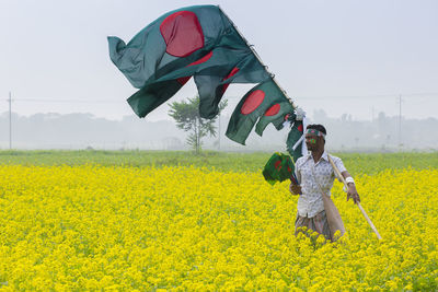 Rear view of woman with umbrella on field