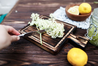 Cropped hand of person preparing food on table