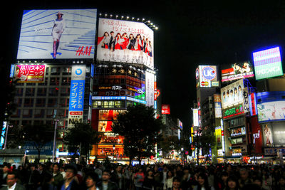 Crowd in city against sky at night