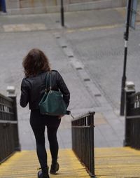 Rear view of woman walking on footpath