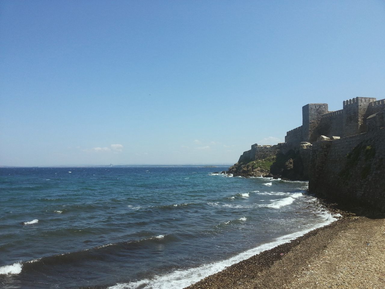 sea, water, clear sky, horizon over water, copy space, blue, beach, built structure, building exterior, architecture, scenics, shore, beauty in nature, tranquil scene, wave, nature, coastline, surf, tranquility, sky