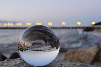 Close-up of crystal ball on beach