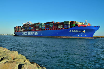 View of ship in sea against clear blue sky