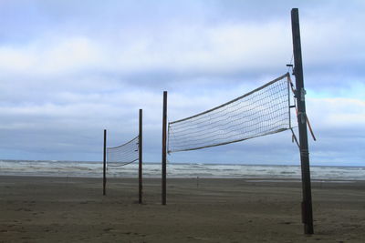 Poles on beach against sky