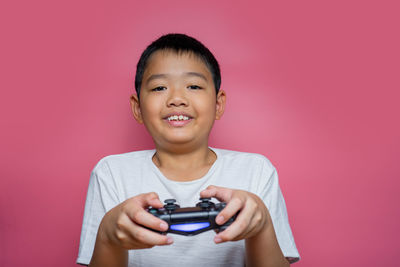 Portrait of smiling boy holding pink face