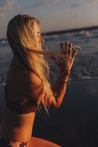 Young woman with arms raised in sea