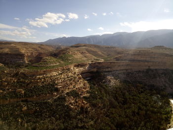 Scenic view of land and mountains against sky