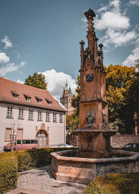 Statue by building against sky in city