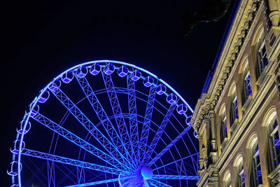 Low angle view of illuminated ferris wheel at night