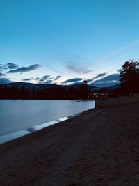 Scenic view of lake against blue sky at dusk