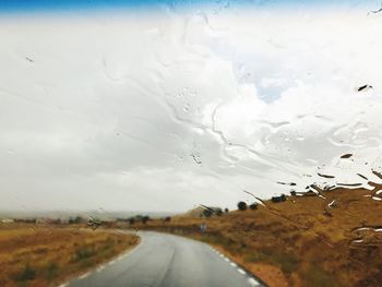 Close-up of wet road against sky