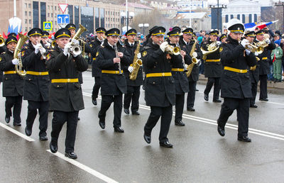 Rear view of people standing on street in city