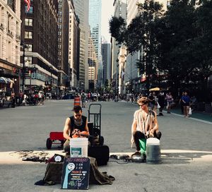 People sitting on street in city