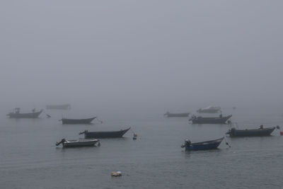 Boats sailing in sea against sky