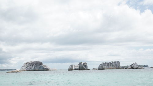 Panoramic shot of rocks on sea against sky
