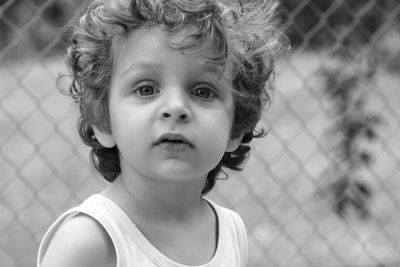 Portrait of cute boy against fence