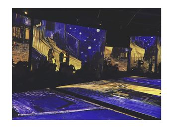 Illuminated street amidst buildings in city at night