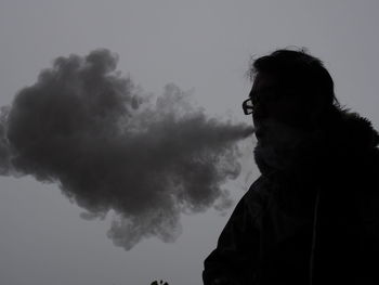 Portrait of man smoking against sky