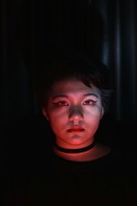 Low lit portrait of a young girl with colored light as accent
