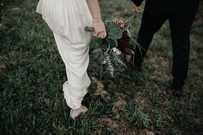 Low section of couple walking on grass