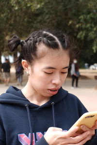 Close-up of young woman using smart phone in park