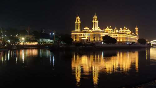 Reflection of buildings in lake at night