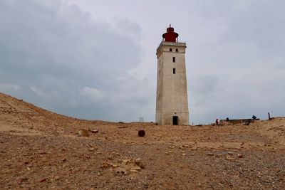 Low angle view of lighthouse amidst buildings against sky
