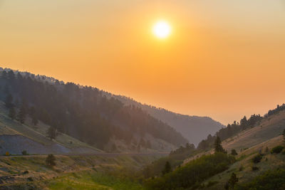 Scenic view of landscape against orange sky