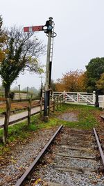 Railroad track by trees against clear sky