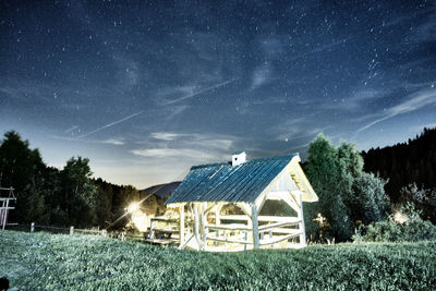 Barn on field against sky at night