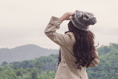 Rear view of woman wearing warm clothing looking at mountains