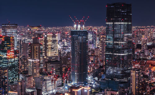 Illuminated cityscape against sky at night