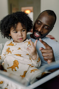 Father touching daughter to count number on fingers