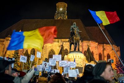 People flags in city against sky at night