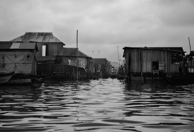 Houses by sea against sky