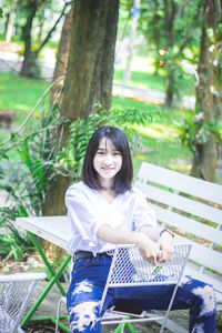 Portrait of a smiling young woman sitting outdoors