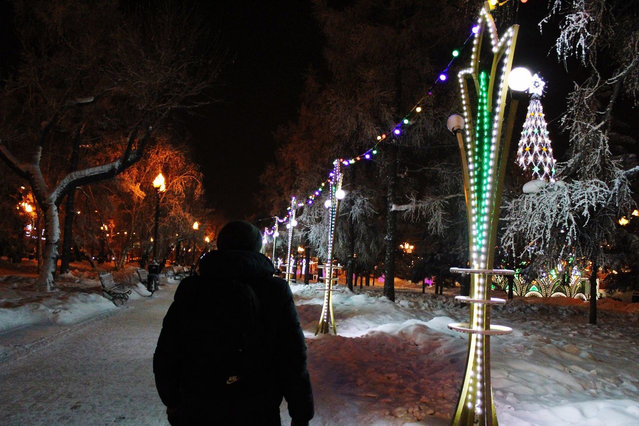 REAR VIEW OF PEOPLE STANDING ON SNOW COVERED STREET